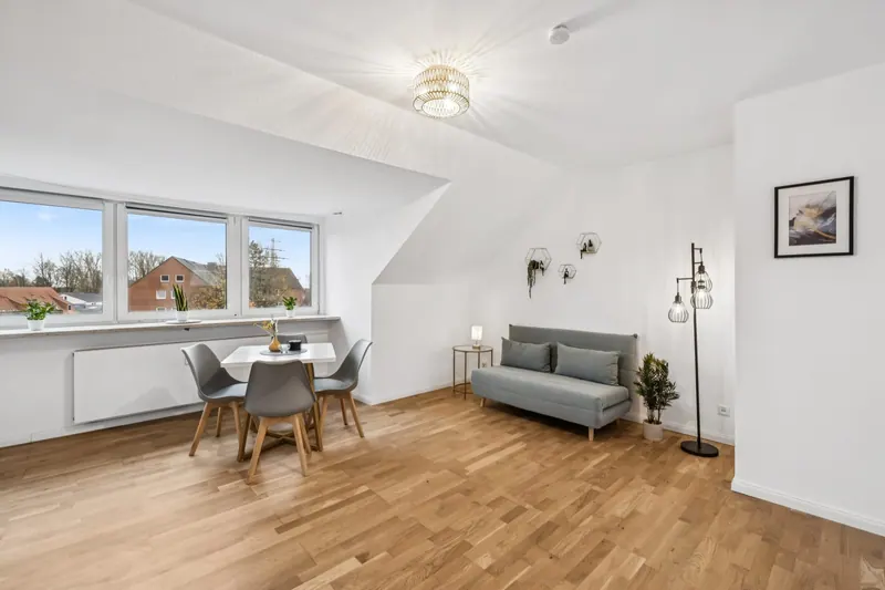 Wohn- und Essbereich unter der Dachschräge mit Fensterband, Esstisch und Sofa